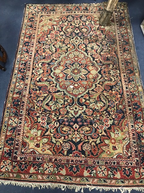 A Persian blue ground rug, woven with a central floral medallion, within a triple border (worn) 210 x 132cm.